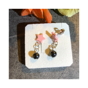 restik med lyserd stjerne og sort perlevedhng. Kirurgisk stl